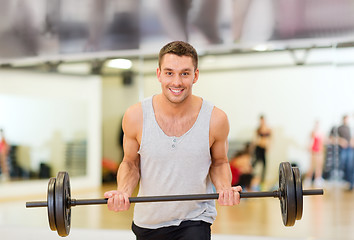 Image showing smiling man with barbell in gym