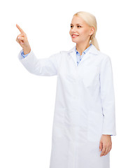 Image showing smiling female doctor pointing to something