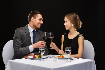 Image showing smiling couple eating main course at restaurant