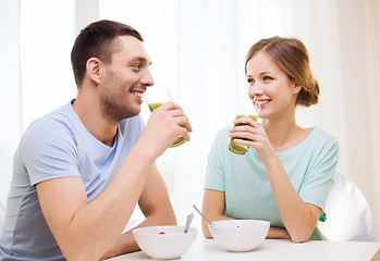 Image showing smiling couple having breakfast at home