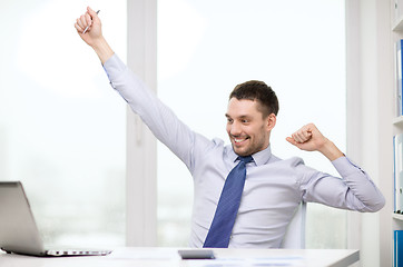 Image showing smiling businessman with laptop and documents