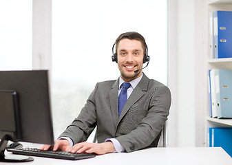 Image showing helpline operator with headphones and computer