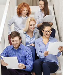 Image showing team with papers and take away coffee on staircase