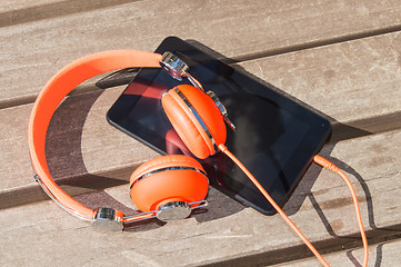 Image showing Orange headphones and tablet pc