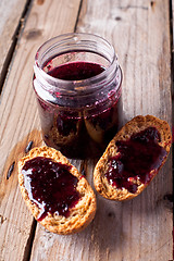 Image showing black currant jam in glass jar and crackers