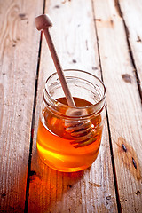 Image showing full honey pot and honey stick 