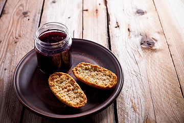 Image showing black currant jam in glass jar and crackers