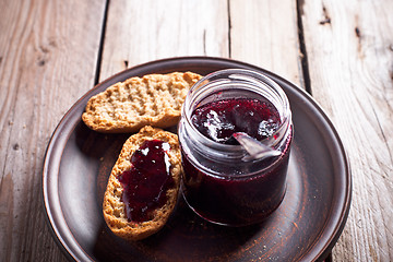 Image showing black currant jam in glass jar and crackers