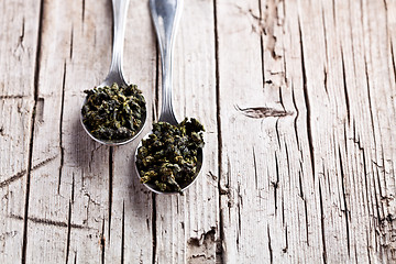 Image showing two spoons of dried green tea leaves 