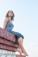 Image showing Attractive girl sitting on roof