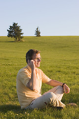 Image showing Man with cell phone in a meadow