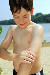 Image showing Boy applying sunscreen