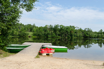 Image showing wooden footbridge and anchored boats water bikes  