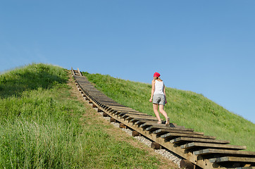 Image showing tourist woman climb strairs on mound hill 