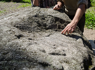 Image showing hand show signs taken of large stone flat surface 