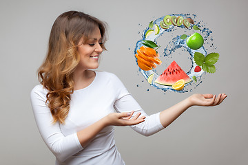 Image showing smiling woman with fruits and water splash