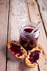 Image showing black currant jam in glass jar and crackers 