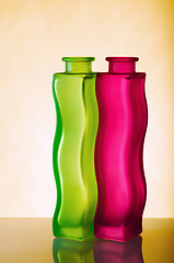 Image showing Two elegant green and red vases on a yellow background, a close 