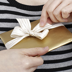 Image showing Young woman holding a present