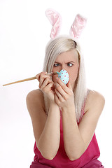 Image showing Woman paints easter egg