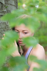 Image showing Young woman hugging a tree.