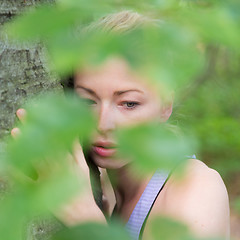 Image showing Young woman hugging a tree.