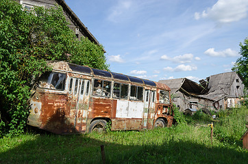 Image showing rusty lonely broken bus in country green field  