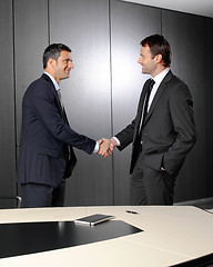 Image showing Serious businessmen shaking hands