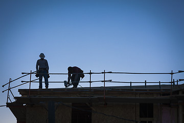 Image showing Construction Workers Silhouette on Roof