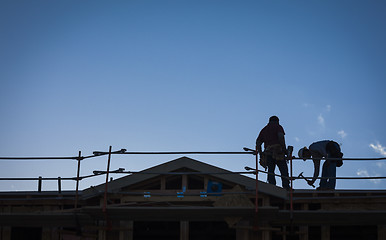 Image showing Construction Workers Silhouette on Roof