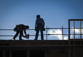 Image showing Construction Workers Silhouette on Roof