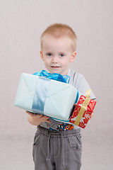 Image showing boy stands with two gifts