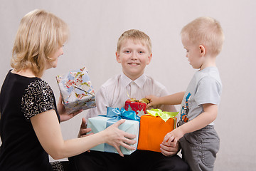 Image showing Mother and brother give teen gifts