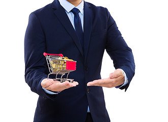 Image showing Businessman putting coin into trolley 