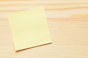 Image showing Yellow notepad over wooden background
