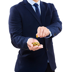 Image showing Businessman holding gold coin