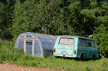 Image showing greenhouse and old mini bus in garden meadow  