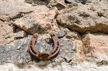 Image showing old iron fortune symbol horseshoe on stone wall  