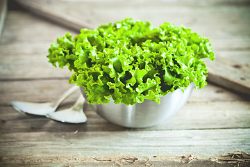 Image showing lettuce salad in metal bowl and spoons