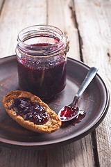 Image showing black currant jam in glass jar and crackers