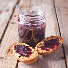Image showing black currant jam in glass jar and crackers 