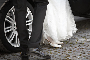 Image showing Bride and groom getting out of the car