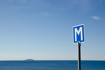 Image showing Passing place road sign by the coast with an island in the horiz