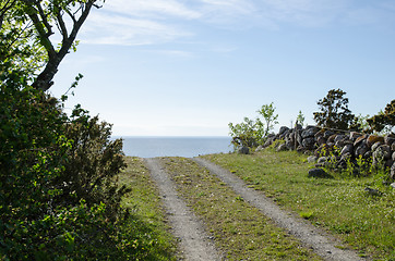 Image showing Rural tracks with blue sky and blue water ahead