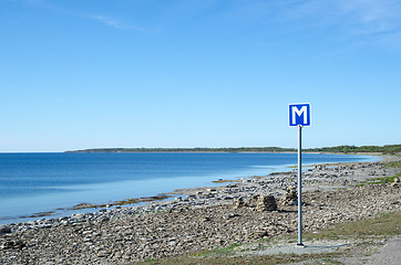 Image showing Scandinavian passing place road sign by a road along a flat rock