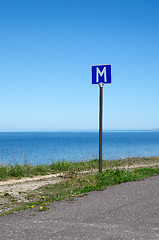 Image showing European road sign passing place by a road along coastline