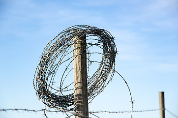 Image showing Rural fence and a roll of barb wire