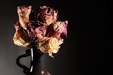 Image showing bouquet of dried roses in ceramic vase