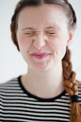 Image showing Attractive woman smirking with eyes closed