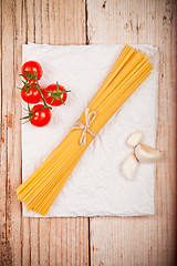 Image showing uncooked pasta with tomatoes and garlic